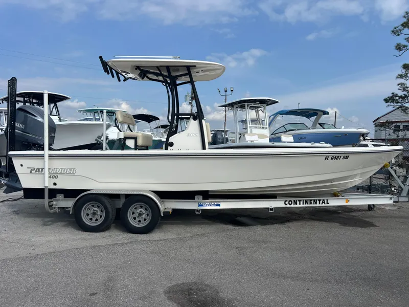 Slide: The Image of 2019 Pathfinder 2400 TRS boat on trailer, parked outdoors under a clear sky. - 3