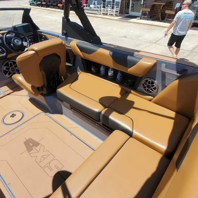 Slide: The Image of 2022 Axis Core Series A22 boat interior with tan leather seats and modern dashboard. - 11