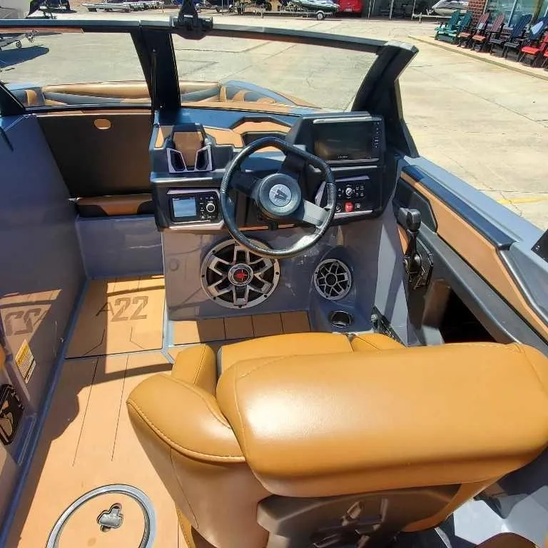Slide: The Image of 2022 Axis Core Series A22 boat interior with tan seating and modern dashboard controls. - 13