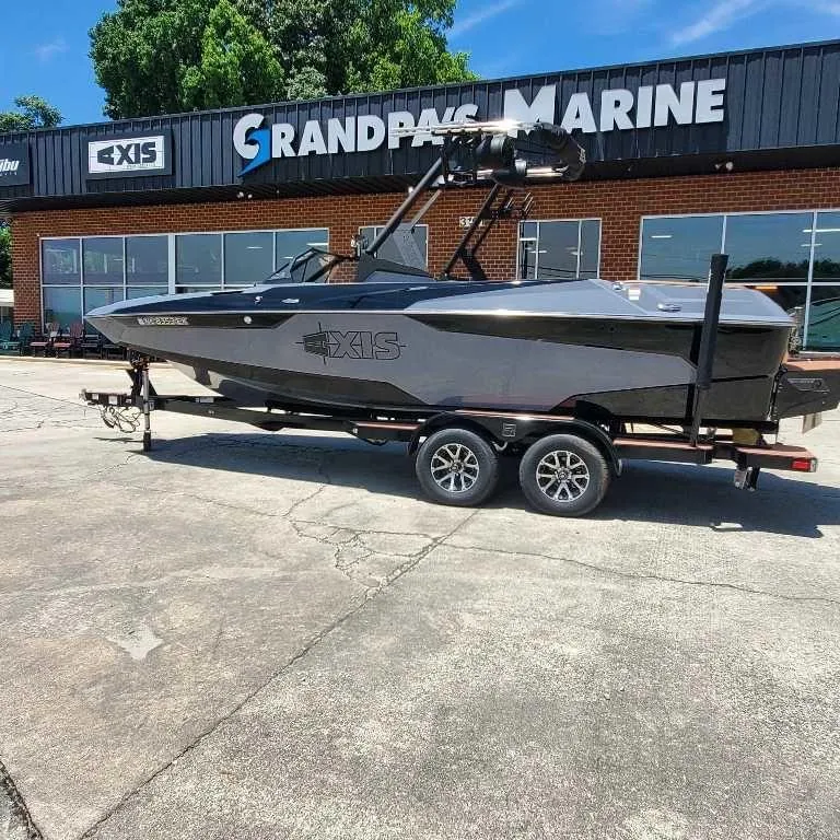 Slide: The Image of 2022 Axis Core Series A22 boat on trailer at dealership, sunny day. - 6