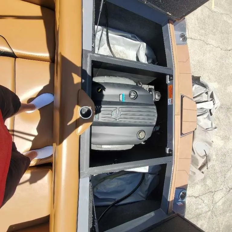 Slide: The Image of 2022 Axis Core Series A22 boat engine compartment with tan seating. - 9