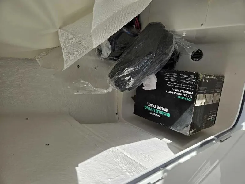 Slide: The Image of Storage compartment of 2025 Key West 203 FS boat with equipment and box. - 12