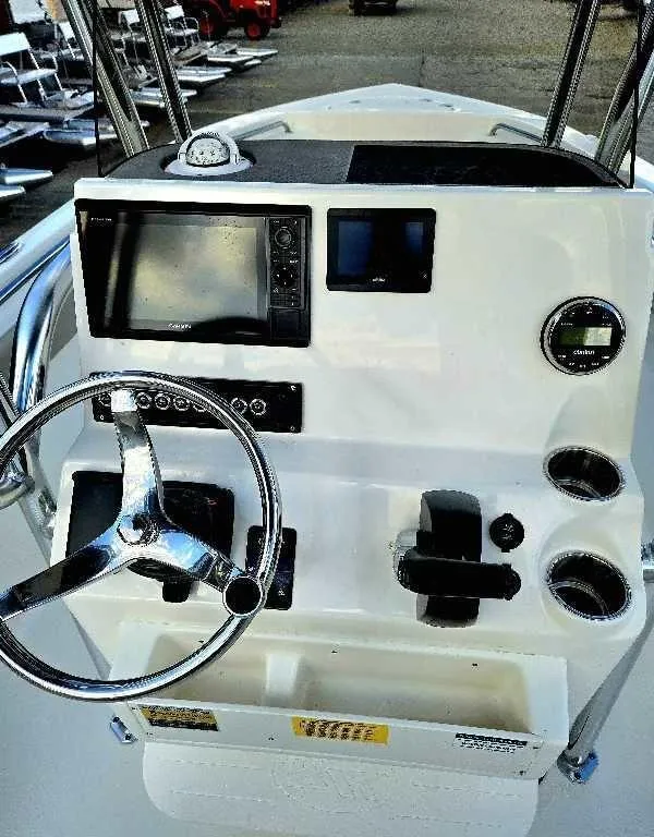 Slide: The Image of 2025 Key West 203 FS boat dashboard with steering wheel and navigation controls. - 9