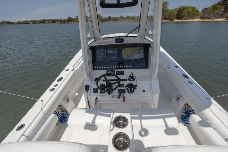 Slide: The Image of 2021 Regulator 28FS boat cockpit with modern controls and seating, on a sunny day. - 17
