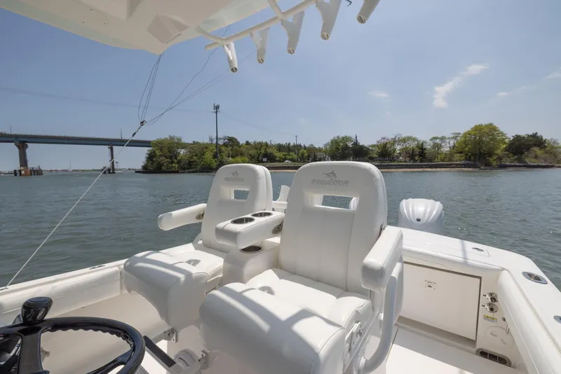 Slide: The Image of 2021 Regulator 28FS boat cockpit with steering wheel and navigation system on a sunny day. - 20