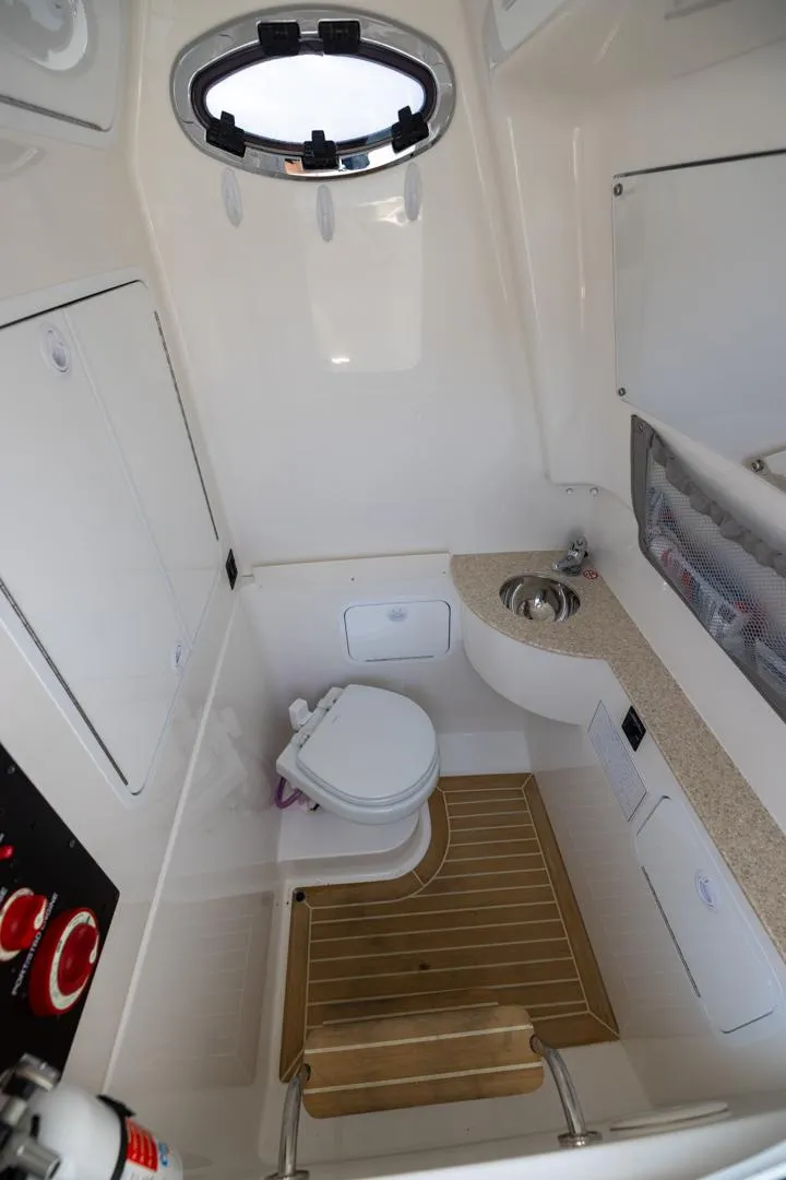 Slide: The Image of 2021 Regulator 28FS boat interior with white seating on calm water. - 22