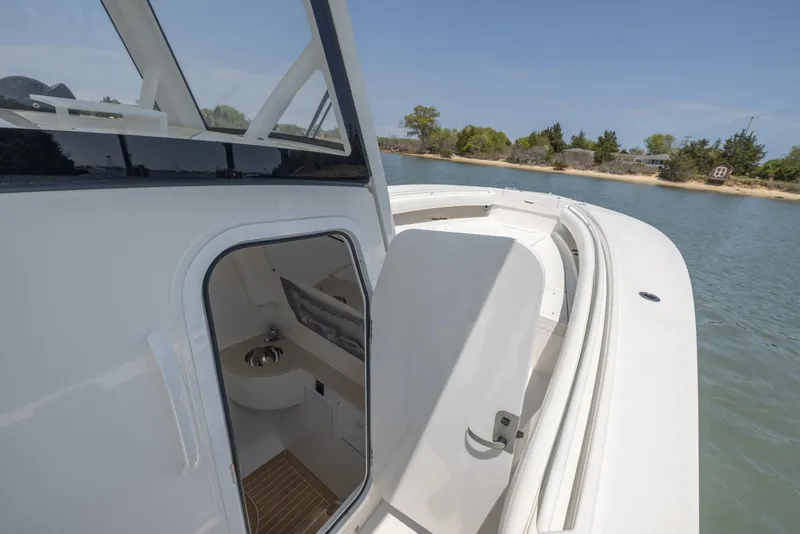 Slide: The Image of 2021 Regulator 28FS boat bathroom with sink, toilet, and storage compartments. - 24