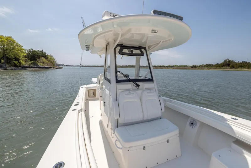 Slide: The Image of 2021 Regulator 28FS boat with open cabin door, showing interior sink, on calm water. - 25