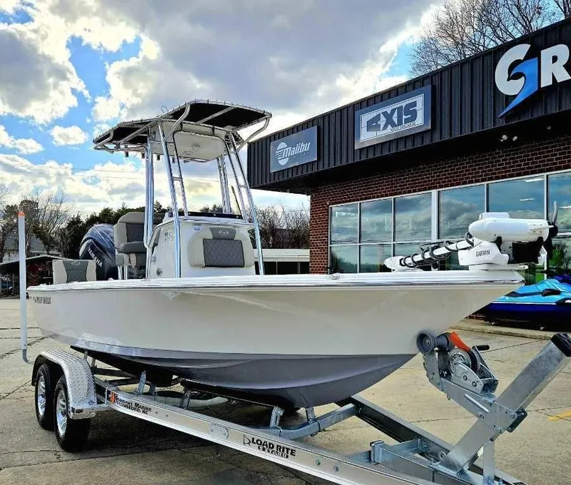 Slide: The Image of 2025 Key West 210 BR boat on trailer outside dealership under cloudy sky. - 1