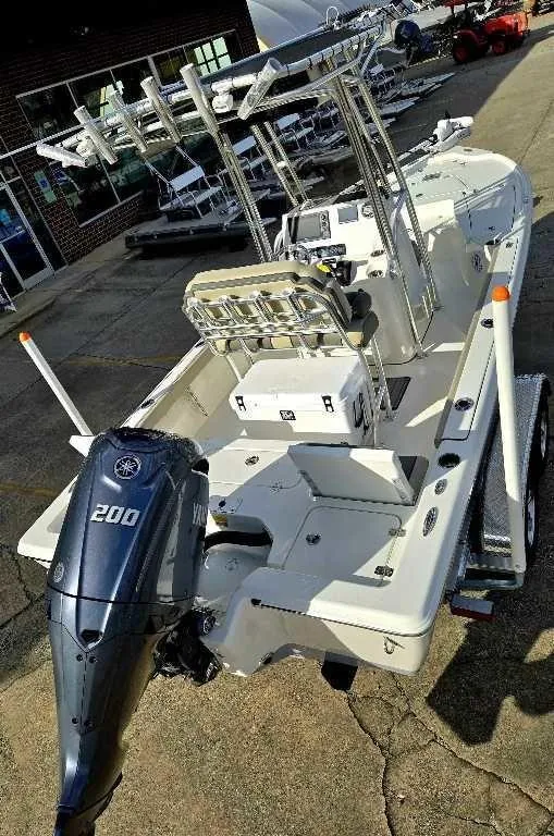 Slide: The Image of 2025 Key West 210 BR boat with Yamaha 200 engine, parked outdoors. - 5