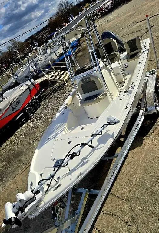 Slide: The Image of 2025 Key West 210 BR boat on trailer, parked outdoors under cloudy sky. - 9