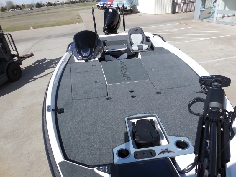 Slide: The Image of 2025 Vexus VXS 21 boat with spacious deck and modern seating in a parking area. - 12