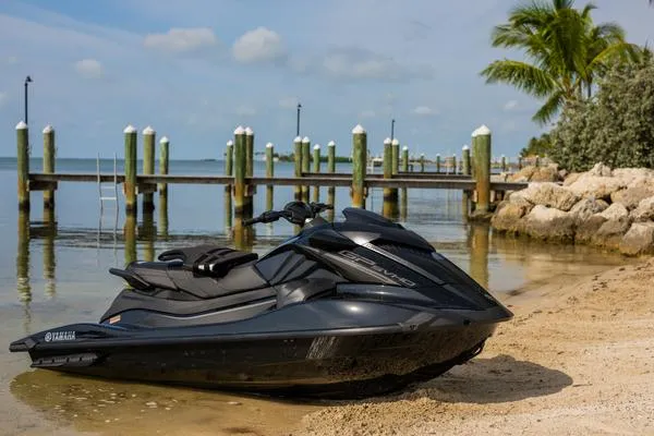 Slide: The Image of 2025 Yamaha Waverunner GP SVHO with Audio on sandy beach near dock and palm trees. - 10