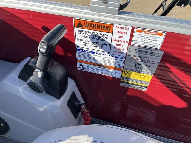Slide: The Image of 2022 Bennington 23 SSBX boat dashboard with warning labels and control lever. - 13