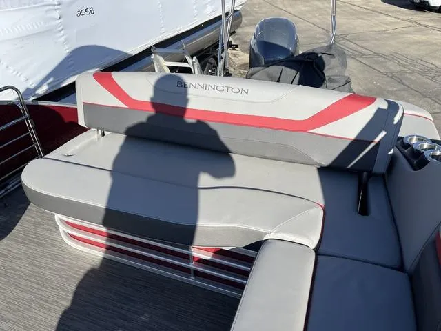 Slide: The Image of 2022 Bennington 23 SSBX boat interior with gray and red seating, shadow visible. - 4