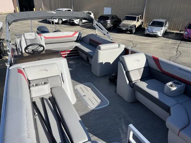 Slide: The Image of 2022 Bennington 23 SSBX pontoon boat with spacious seating and modern design in a parking lot. - 7