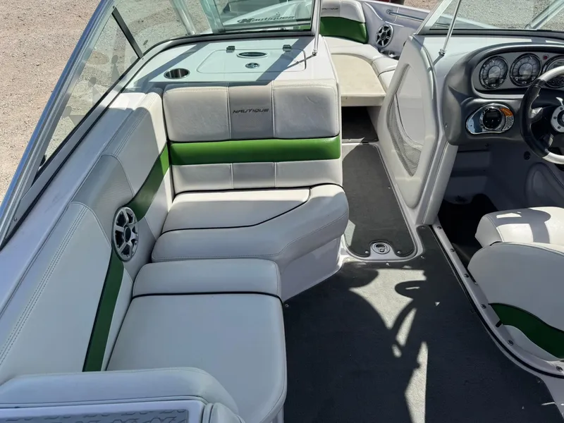 Slide: The Image of 2008 Nautique Super Air 220 boat interior with white and green seating, dashboard, and steering wheel. - 15