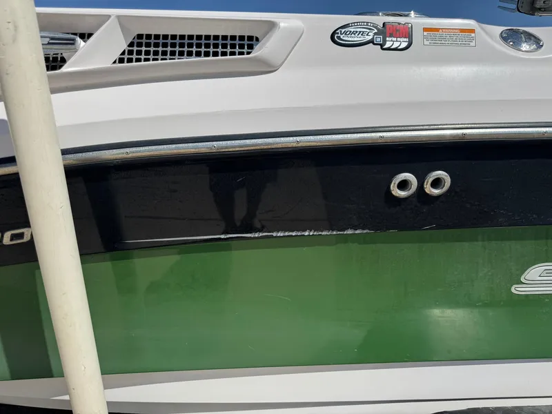 Slide: The Image of 2008 Nautique Super Air 220 boat with green and black hull, visible branding stickers. - 7