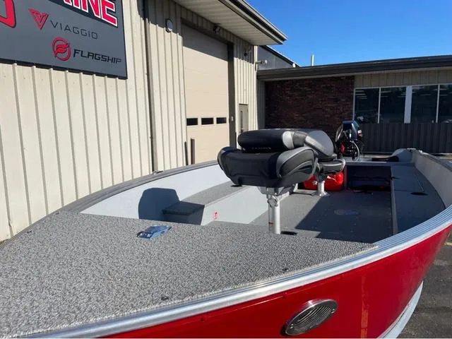 Slide: The Image of 2025 Lund Fury 1600 Tiller Heritage Edition boat, red exterior, parked outside a building. - 4