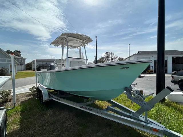 Slide: The Image of 2025 May-Craft 2000 Cape Classic boat on trailer, parked outdoors under a partly cloudy sky. - 3