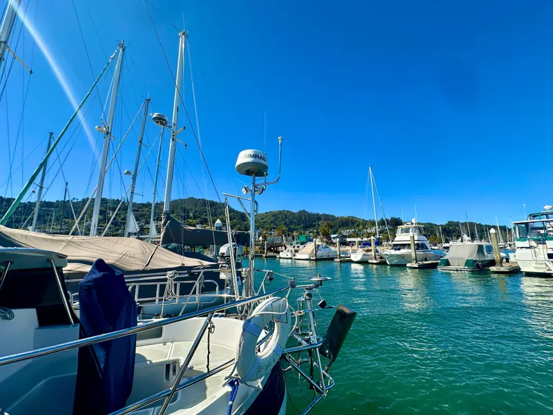 Slide: The Image of Sailboats docked in a marina under clear blue skies, featuring a 1996 Valiant 39. - 11