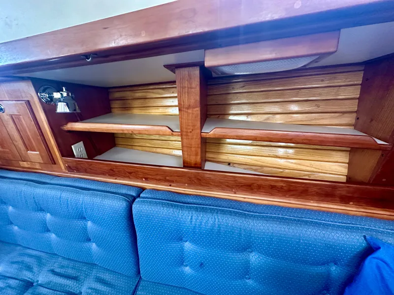 Slide: The Image of Wooden interior shelving and blue cushioned seating in a 1996 Valiant 39 boat. - 27