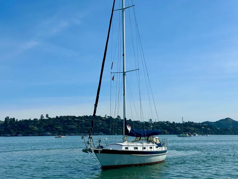 Slide: The Image of Sailboat Valiant 39 (1996) on calm water with scenic background. - 3