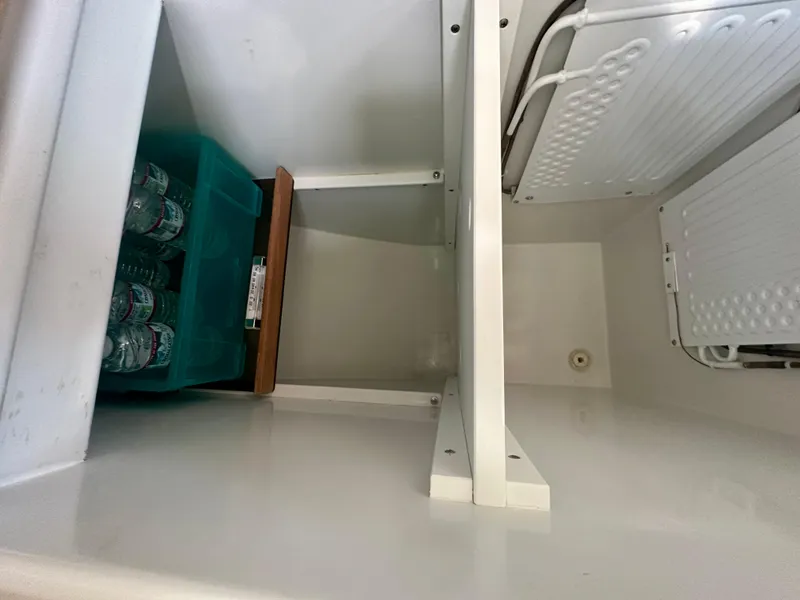 Slide: The Image of Storage compartment in a 1996 Valiant 39 boat with water bottles. - 36