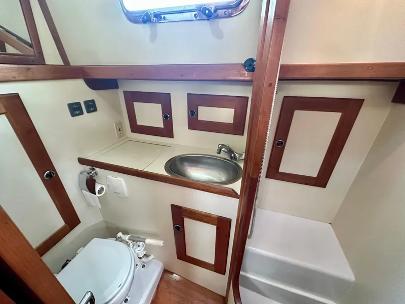 Slide: The Image of 1996 Valiant 39 yacht bathroom with sink, toilet, and wooden accents. - 38