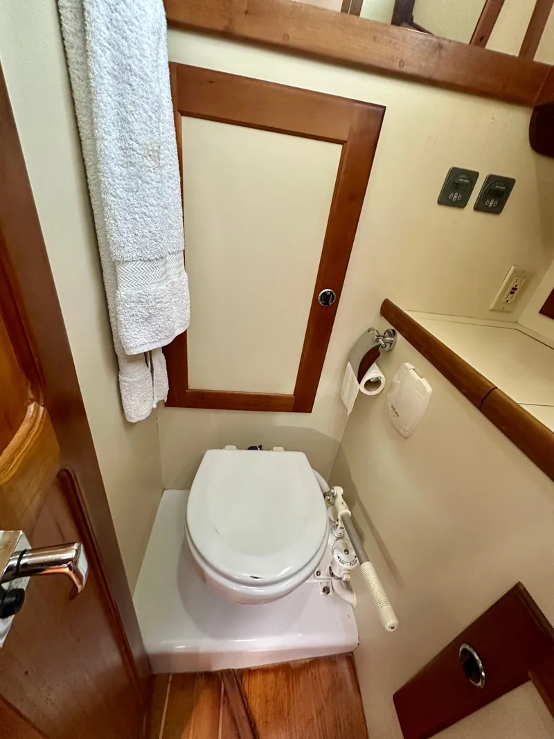 Slide: The Image of Compact bathroom in a 1996 Valiant 39 yacht with wooden accents and white fixtures. - 40
