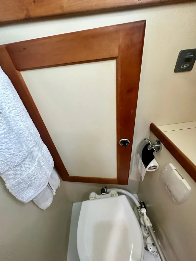 Slide: The Image of 1996 Valiant 39 bathroom with wooden door, white towel, and toilet. - 41
