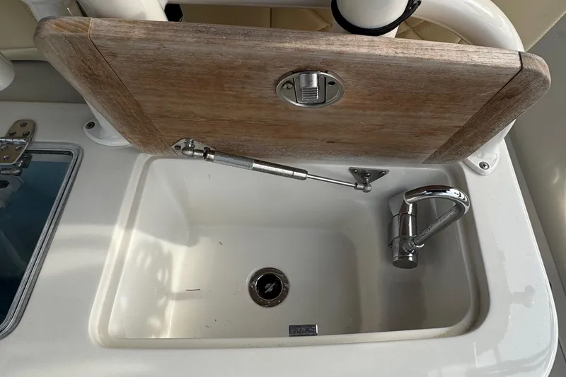 Slide: The Image of 2015 Chris-Craft Catalina 29 boat sink with wooden cover and chrome faucet. - 12