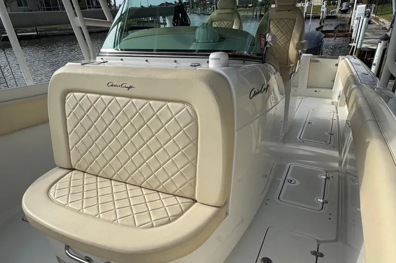 Slide: The Image of 2015 Chris-Craft Catalina 29 boat with luxurious quilted seating, docked by the water. - 13