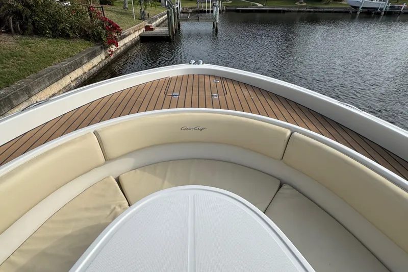 Slide: The Image of 2015 Chris-Craft Catalina 29 boat with teak deck and cushioned seating by the water. - 19