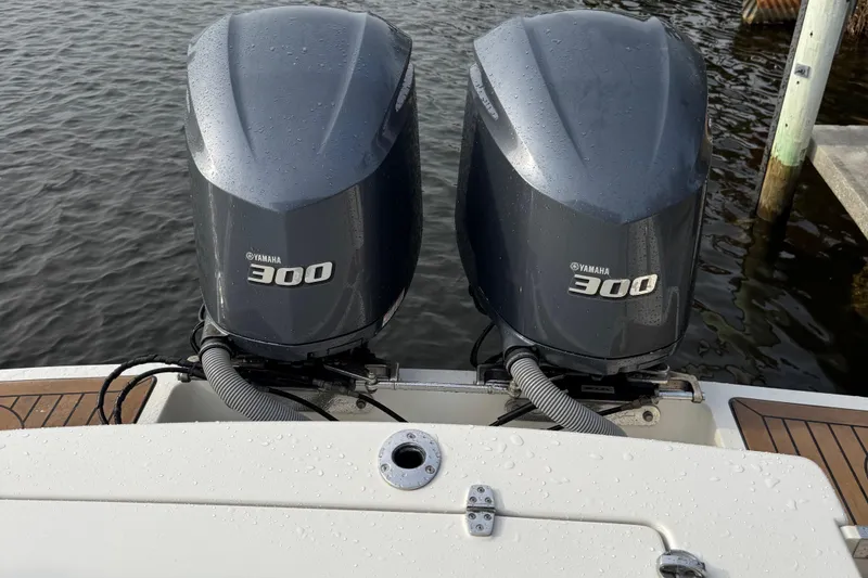 Slide: The Image of Twin Yamaha 300 engines on a 2015 Chris-Craft Catalina 29 boat, docked by the water. - 4