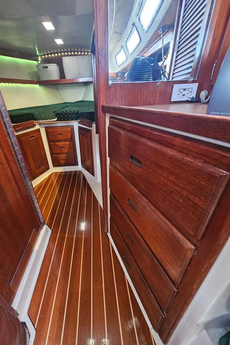 Slide: The Image of 1986 Catalina 36 yacht interior with polished wood cabinets and flooring. - 20
