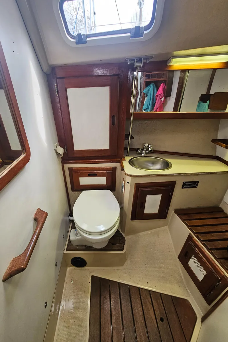 Slide: The Image of 1986 Catalina 36 yacht bathroom with sink, toilet, and wooden accents. - 21