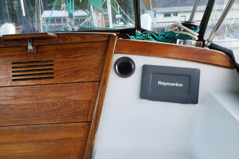 Slide: The Image of 1986 Catalina 36 sailboat cockpit with Raymarine equipment and wooden paneling. - 23