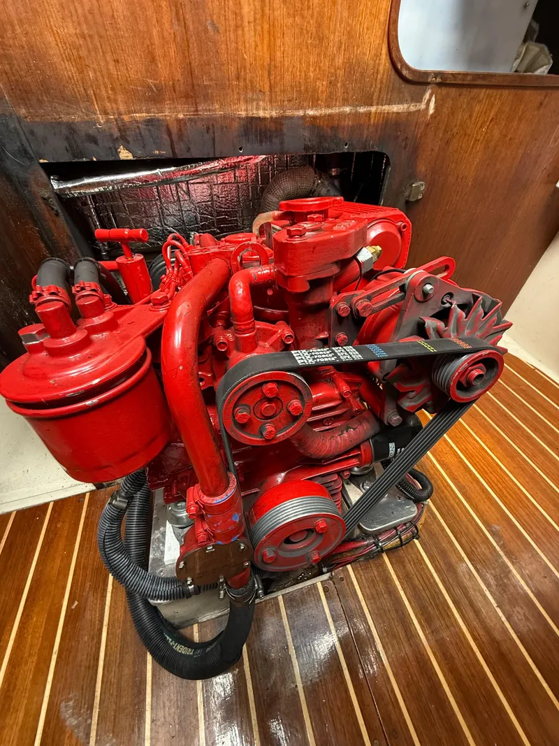 Slide: The Image of Red engine inside a 1986 Catalina 36 sailboat, mounted on wooden flooring. - 30