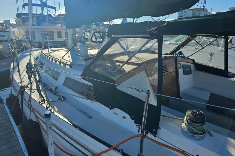 Slide: The Image of 1986 Catalina 36 sailboat docked at marina, featuring spacious deck and cockpit area. - 36