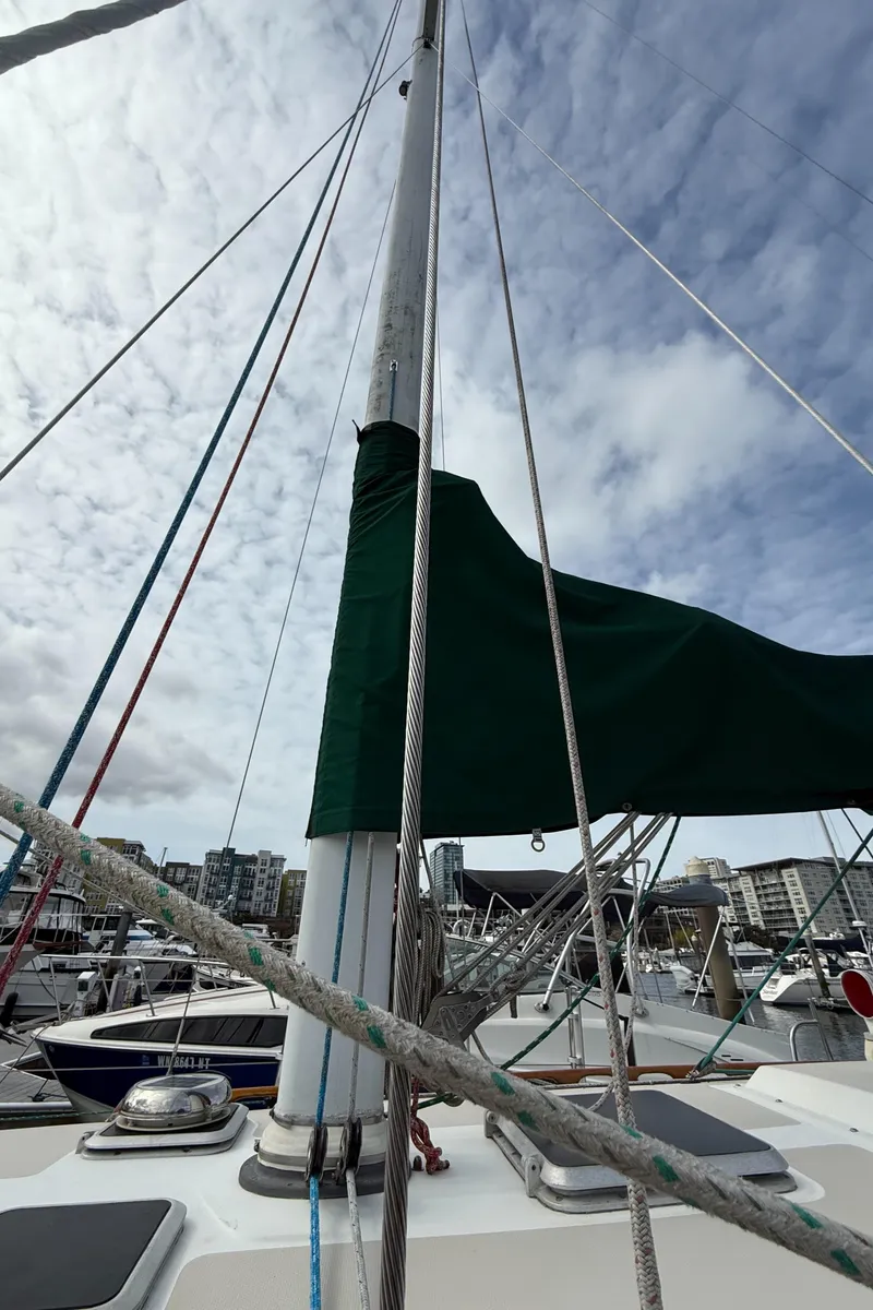 Slide: The Image of 1986 Catalina 36 sailboat mast and rigging against a cloudy sky in a marina. - 38