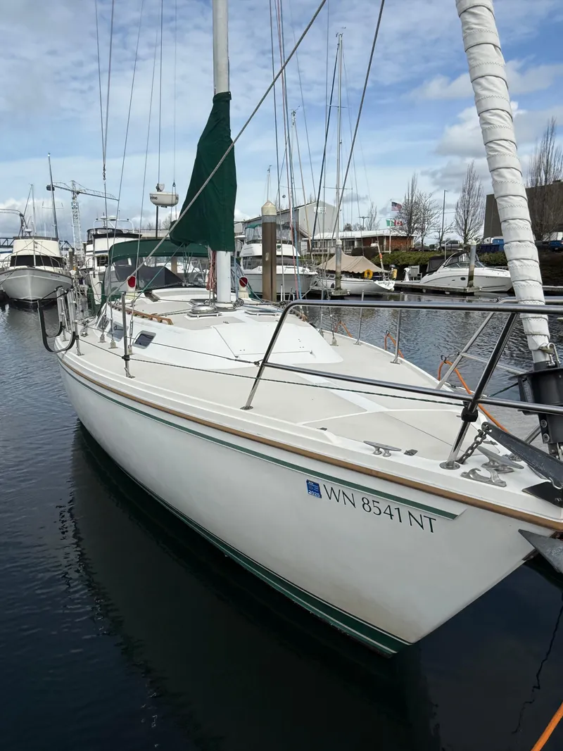 Slide: The Image of 1986 Catalina 36 sailboat docked in a marina, featuring a white hull and green sail cover. - 39