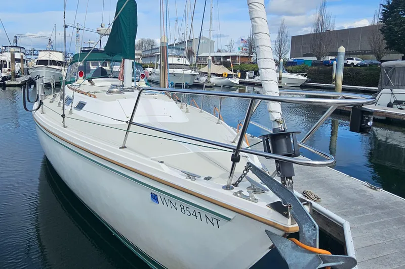 Slide: The Image of 1986 Catalina 36 sailboat docked at marina, featuring white hull and green sail cover. - 41