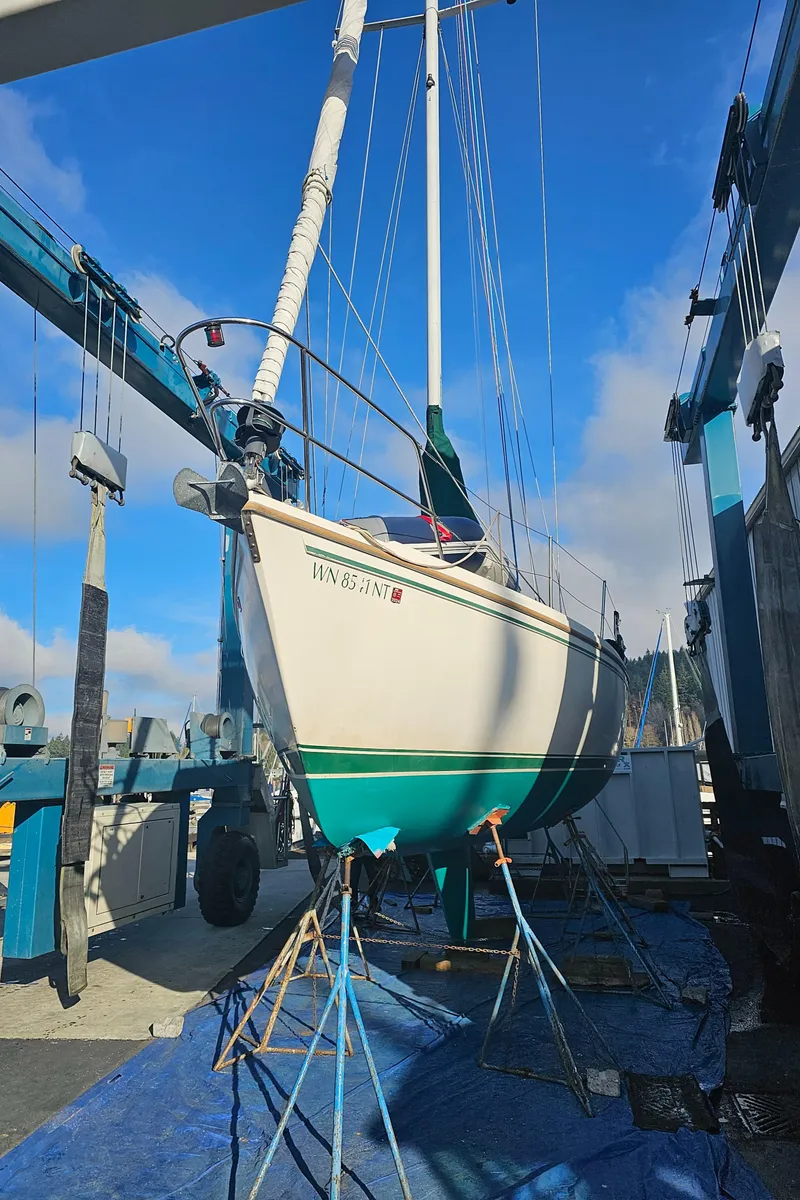 Slide: The Image of 1986 Catalina 36 sailboat on stands in a boatyard under a clear blue sky. - 45