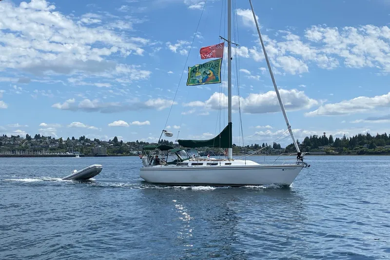 Slide: The Image of 1986 Catalina 36 sailboat cruising on a sunny day with flags flying. - 54