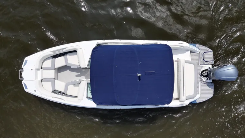 Slide: The Image of Overhead view of 2019 Cobalt 25 SC boat with blue cover on water. - 11