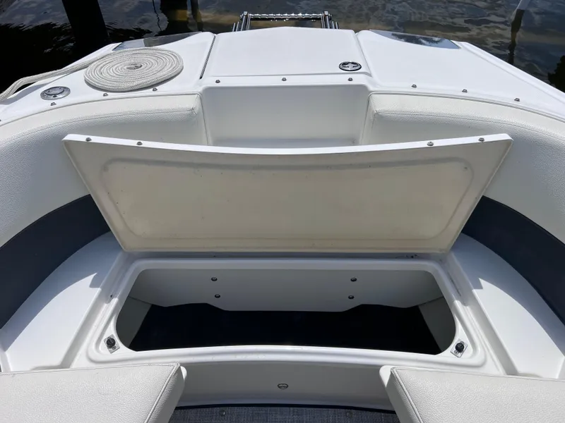 Slide: The Image of 2019 Cobalt 25 SC boat storage compartment, open, showing interior space. - 22
