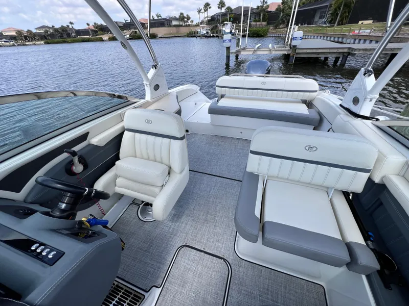 Slide: The Image of 2019 Cobalt 25 SC boat interior with plush seating, docked in fresh water. - 24