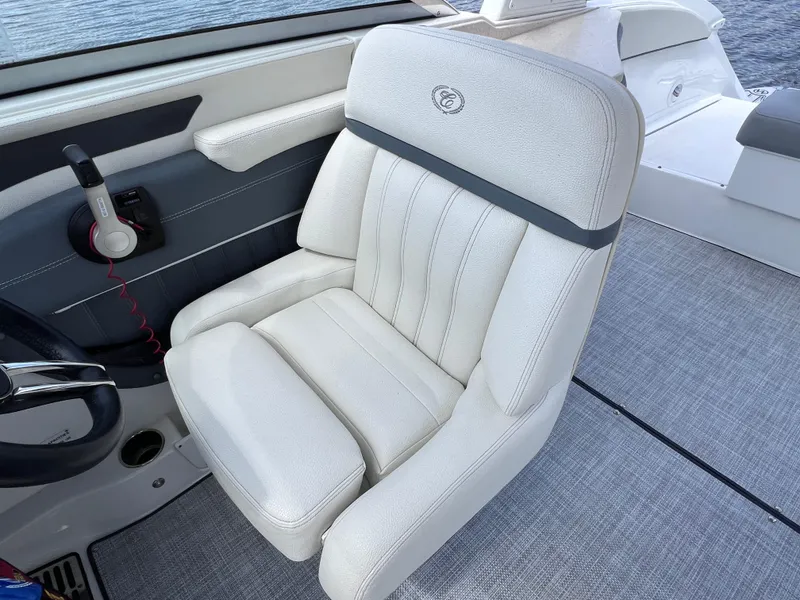 Slide: The Image of 2019 Cobalt 25 SC boat interior with white captain's chair and steering wheel. - 27