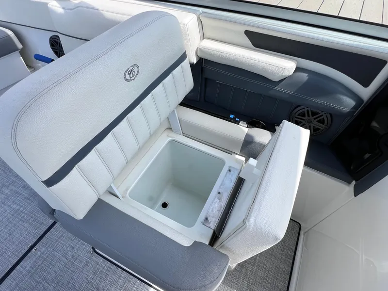 Slide: The Image of 2019 Cobalt 25 SC boat interior with open storage compartment under seat. - 31